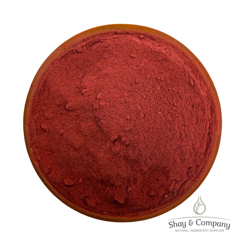 Red powder pigment in wooden bowl from Shay & Company natural ingredient supplier.