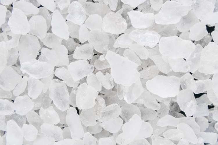Close-up view of white sea salt crystals and granules scattered together.