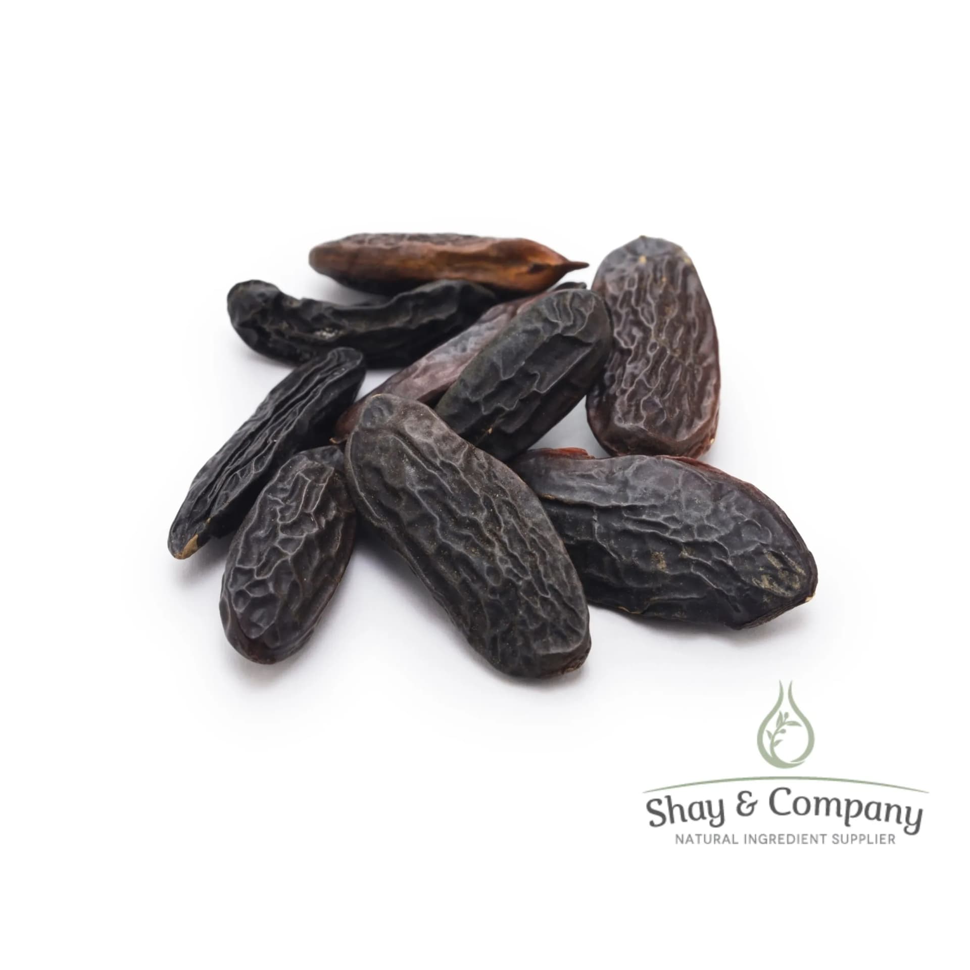 A group of large, brown Tonka Beans on white background.