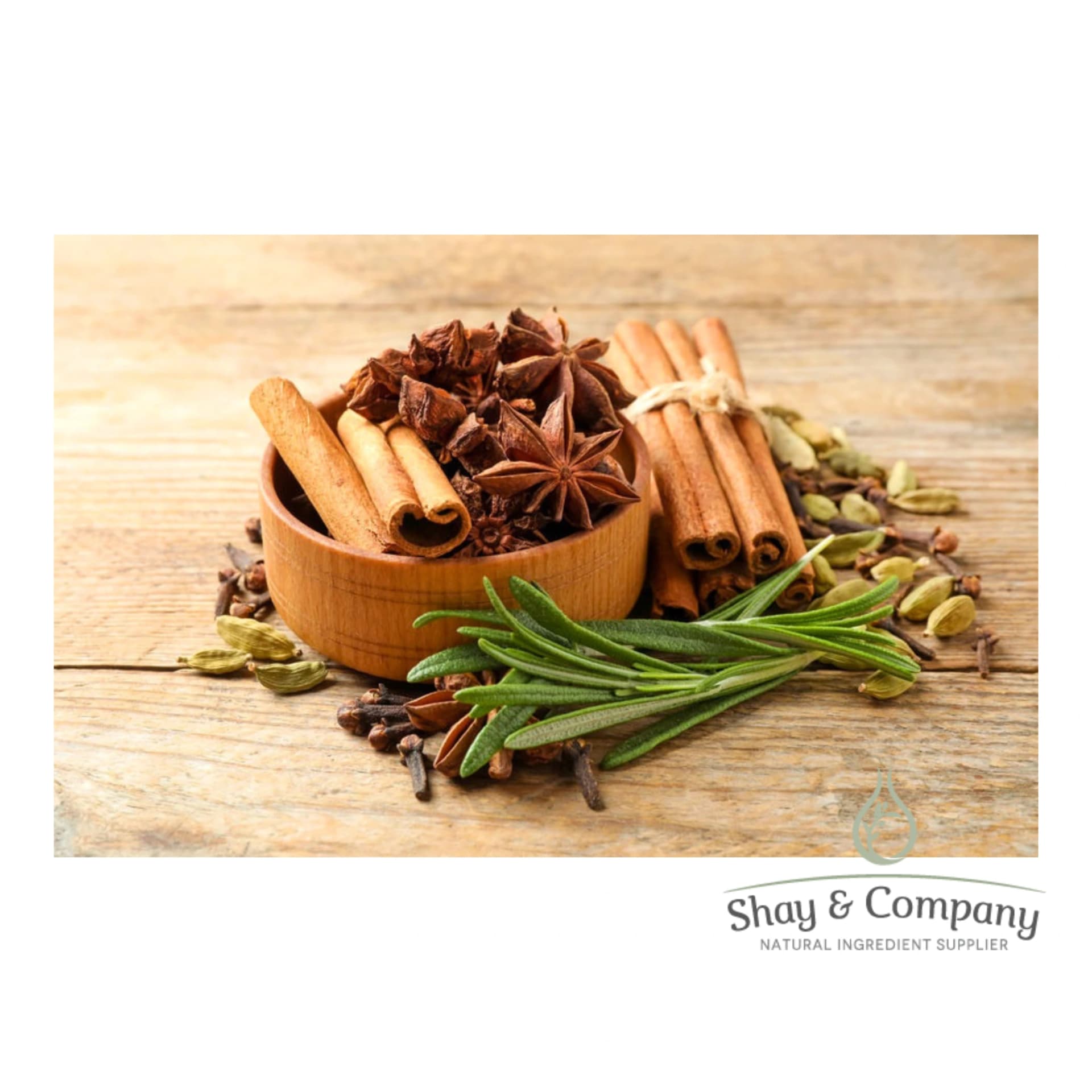 Wooden Bowl with cinnamon sticks, star anise pods, cardamom seeds, and a branch rosemary in and around it.