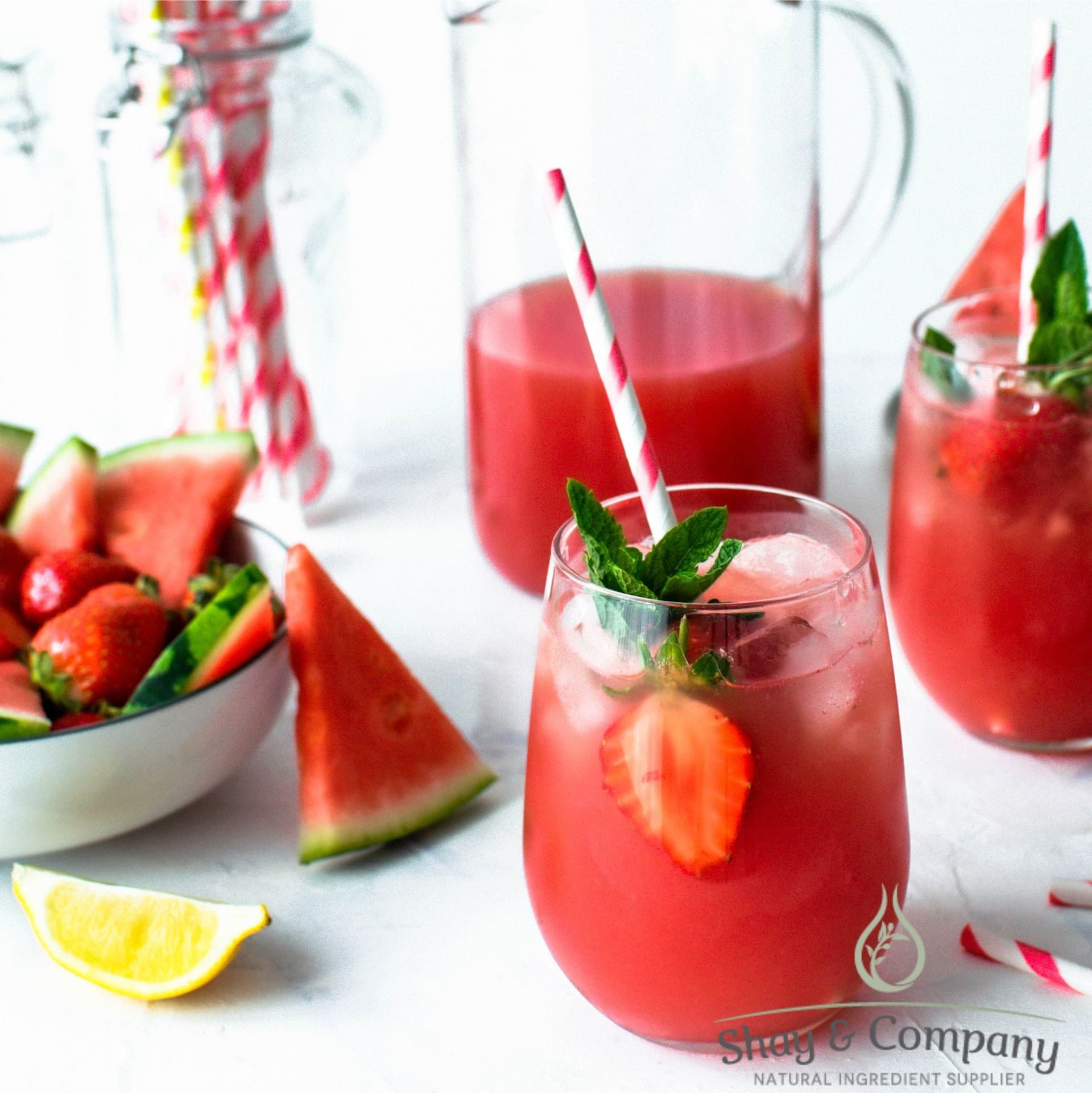 Refreshing strawberry and watermelon punch served in glasses with ice, mint garnish, and striped straws.